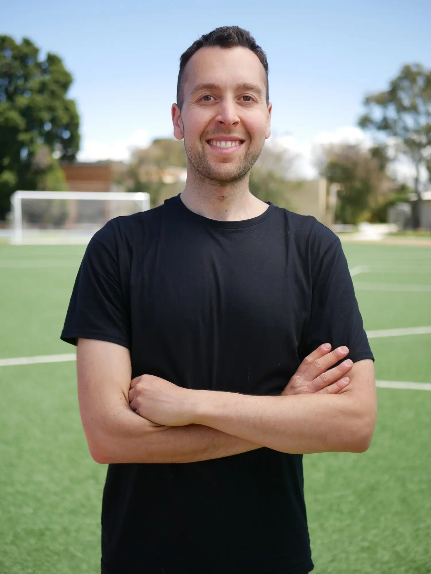Jake Sugarman, physiotherapist and performance coach, standing on a football pitch